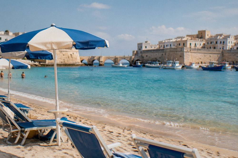 Sunbeds and umbrellas on a sandy Ionian beach near Gallipoli in morning light