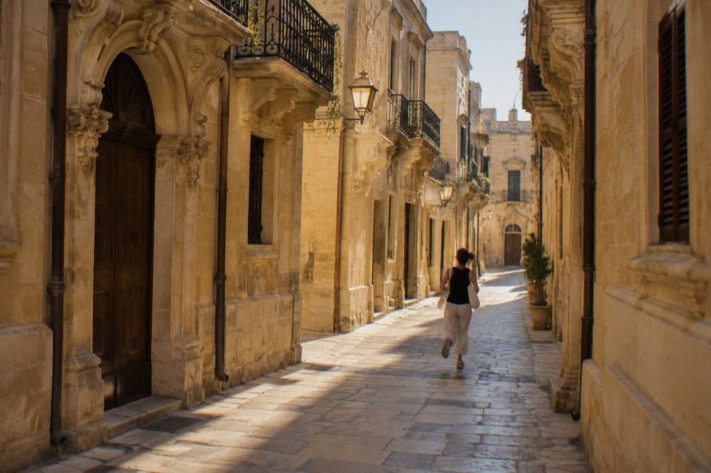 A narrow stone street in Lecce's old town with warm lamplight and baroque doorways