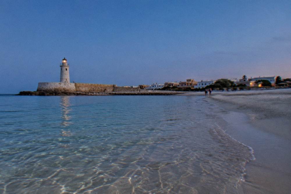 Clear shallow water over sand with a distant sandy horizon line