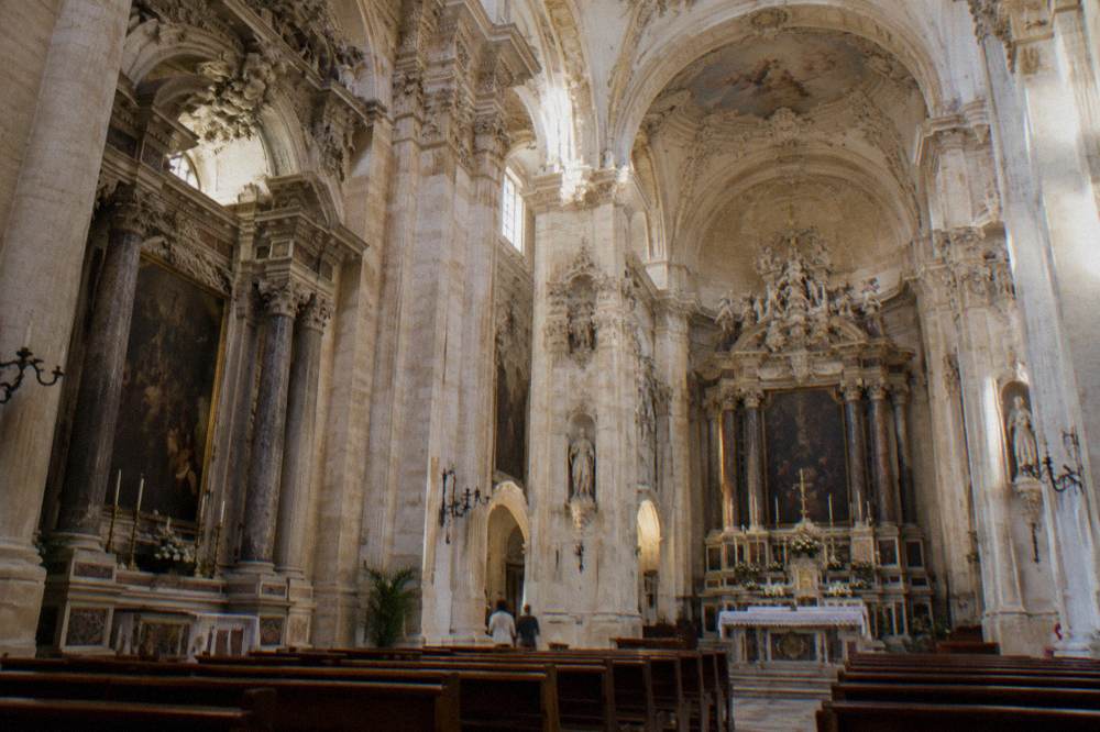 An interior of a baroque church with side altars and stone columns