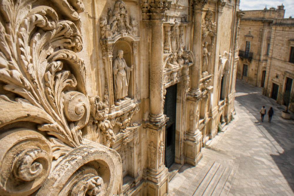 A detail of carved foliage and scrollwork in golden limestone