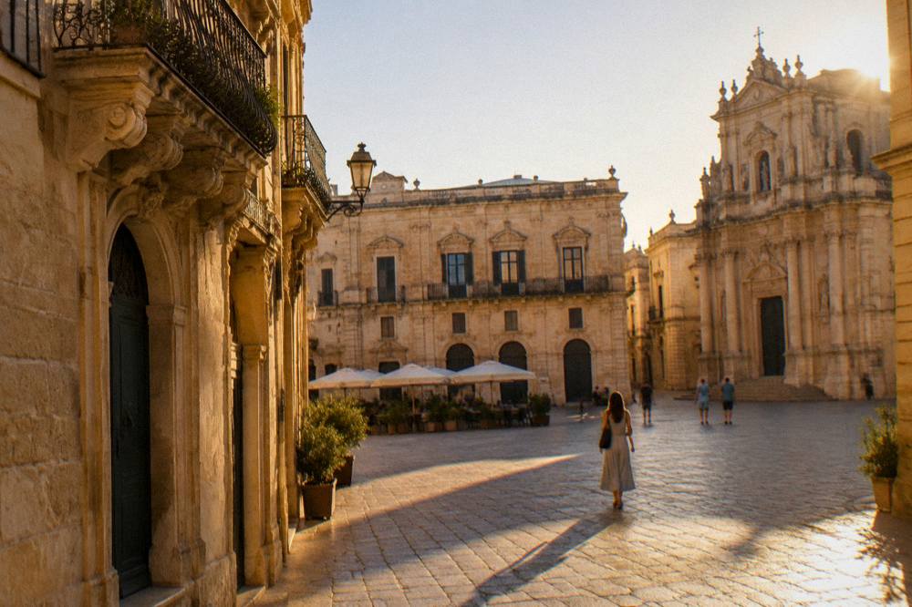 An old town square at dusk with glowing limestone facades