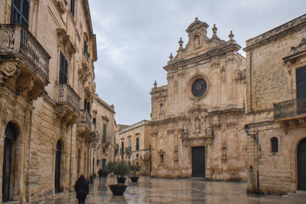 Rose window and upper facade of a baroque church in golden limestone