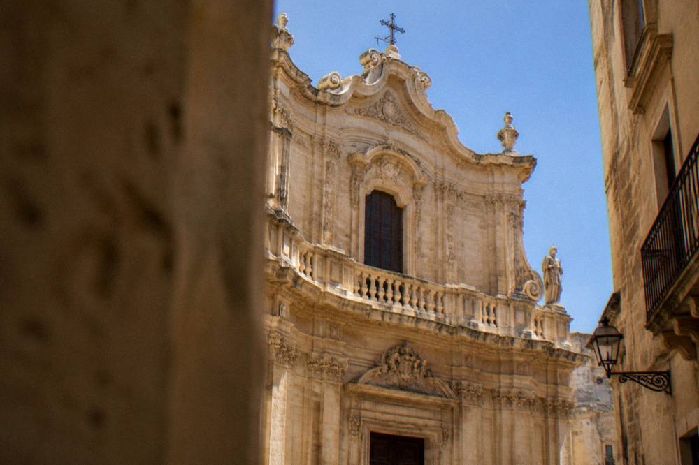 The upper concave section of the Chiesa di San Matteo facade against a clear sky