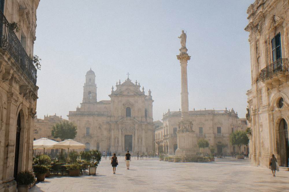 Stone column with a saint's statue rising above a square in Lecce