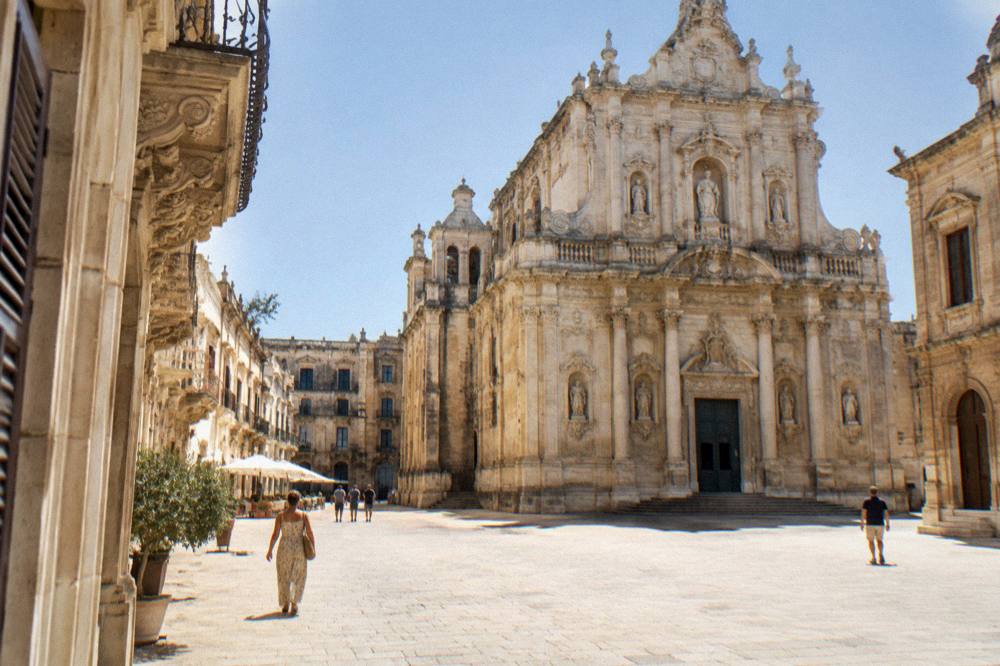Sunlit limestone square with a cathedral facade in Lecce