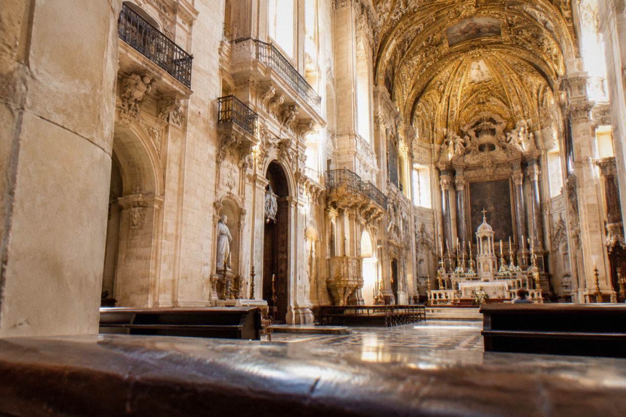 Baroque church interior with an ornate gilded ceiling and stone altars