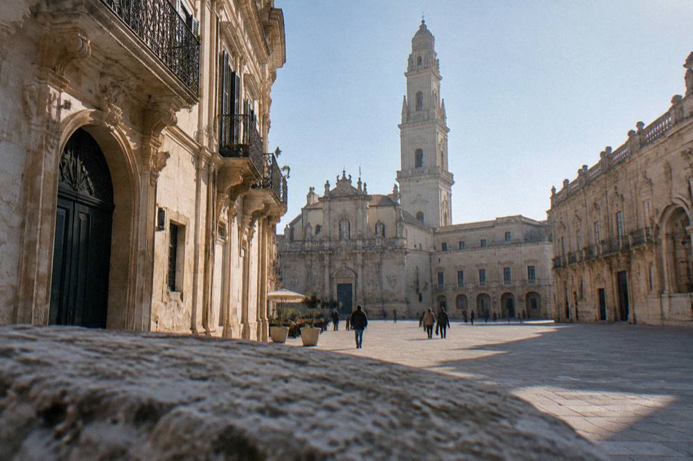 Cathedral square with baroque buildings and a tall bell tower