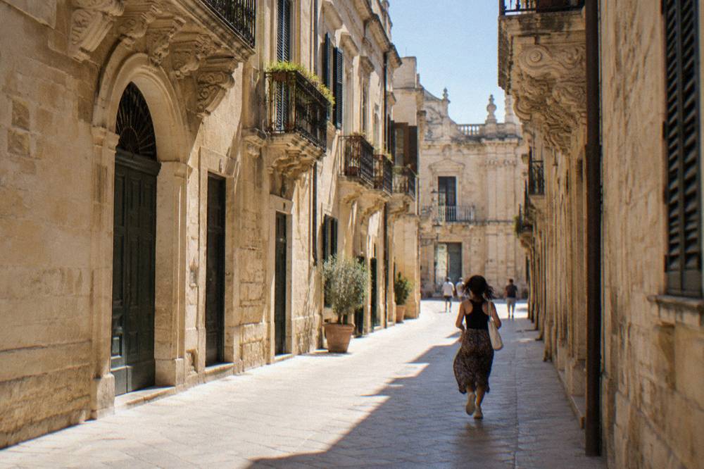 Sunlit street in a southern Italian old town with baroque stone facades