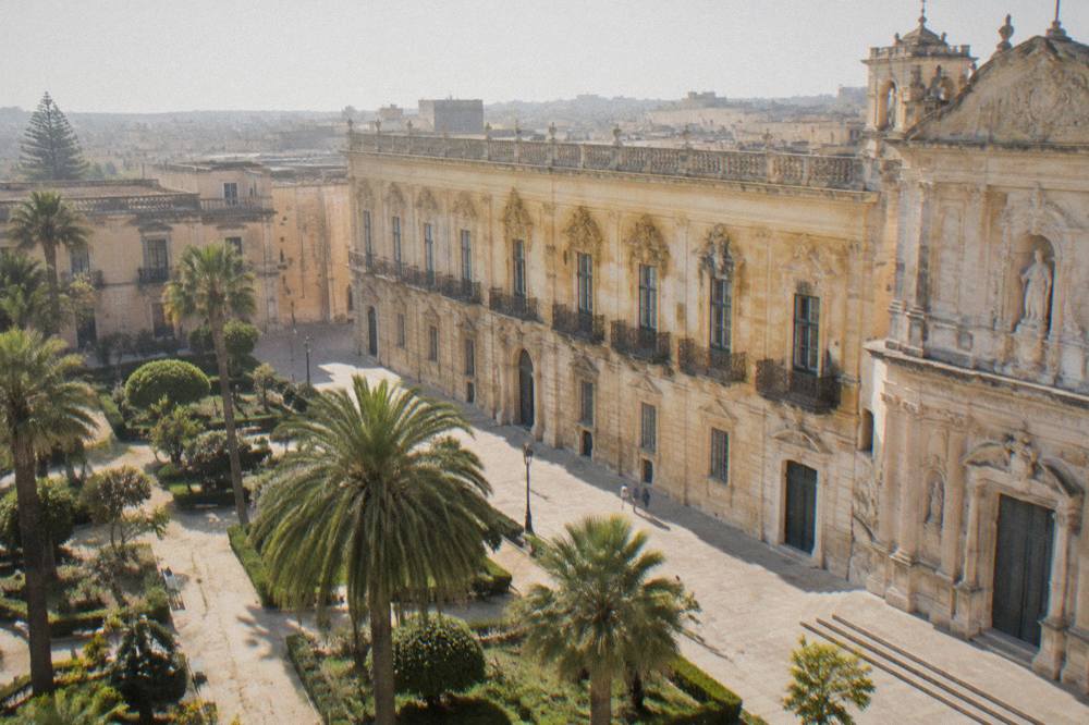A public garden with palm trees and stone paths in an Italian city