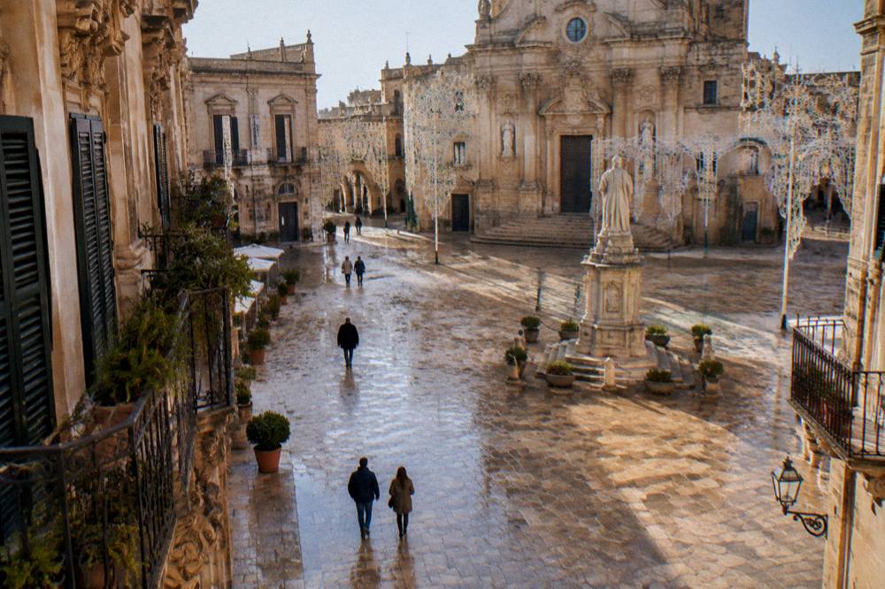A baroque square decorated with festive lights in a southern Italian city