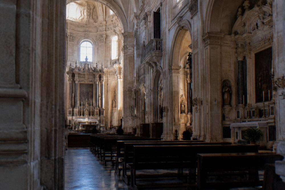 The nave and side altars inside Lecce Cathedral lit by windows
