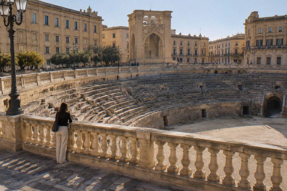 A stone balustrade overlooking the sunken Roman amphitheatre ellipse in the middle of a city square