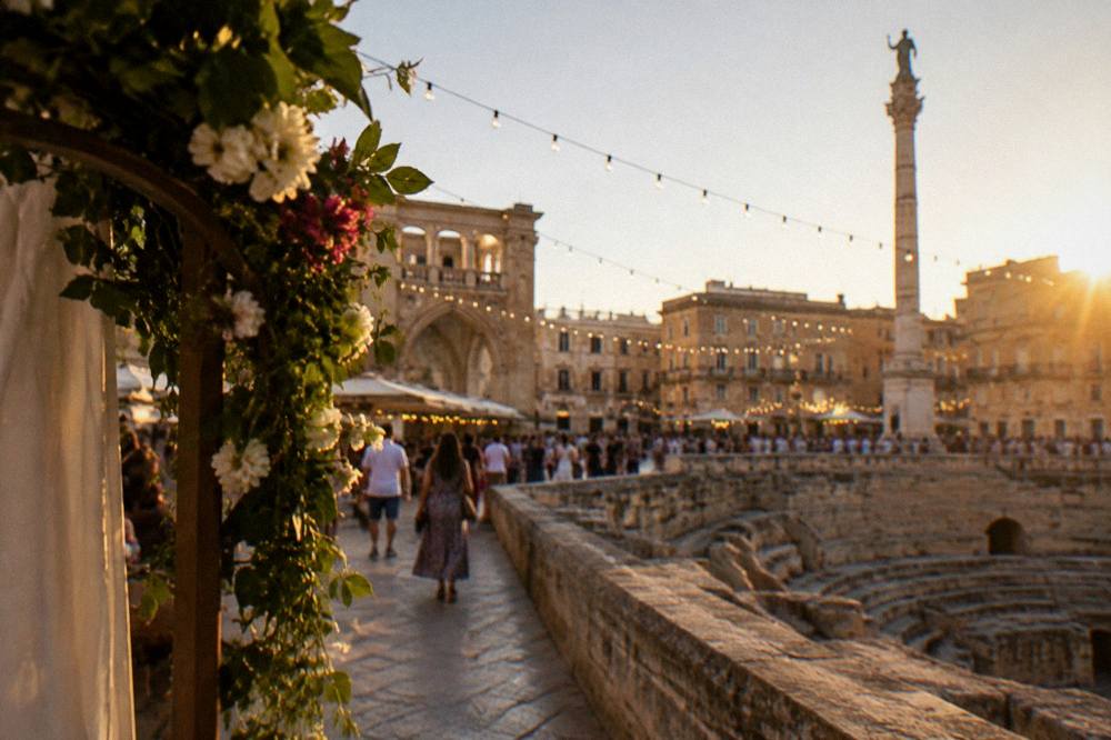 A festival evening in the square with strings of decorative lights spanning the space above crowded walkways