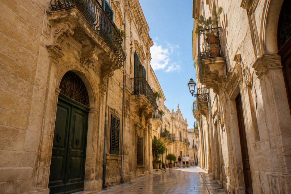 A narrow golden stone street in Lecce's old town lined with old buildings