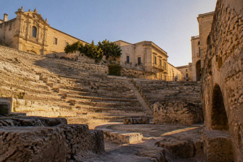 Interior of an archaeological house museum showing exposed ancient walls and stratified layers below floor level