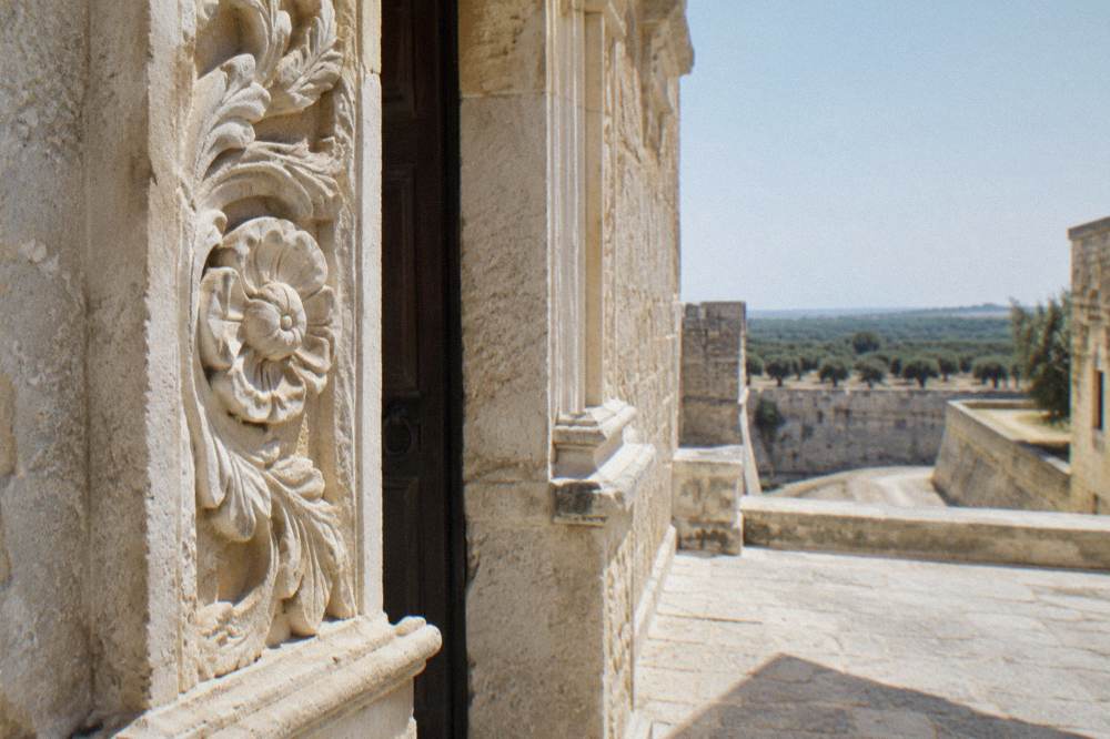A close view of carved pale limestone detail on an old village doorway