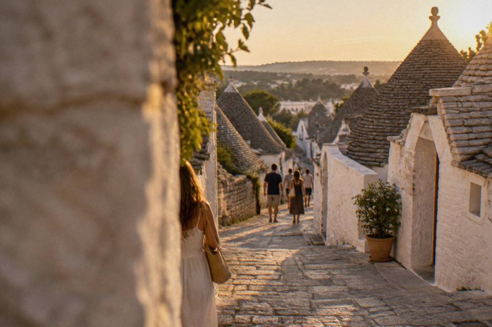 A narrow street of trulli with conical roofs seen from a lane