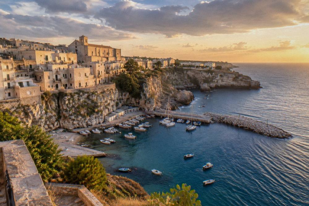 Sunset light on the pale stone houses of a small Salento clifftop town