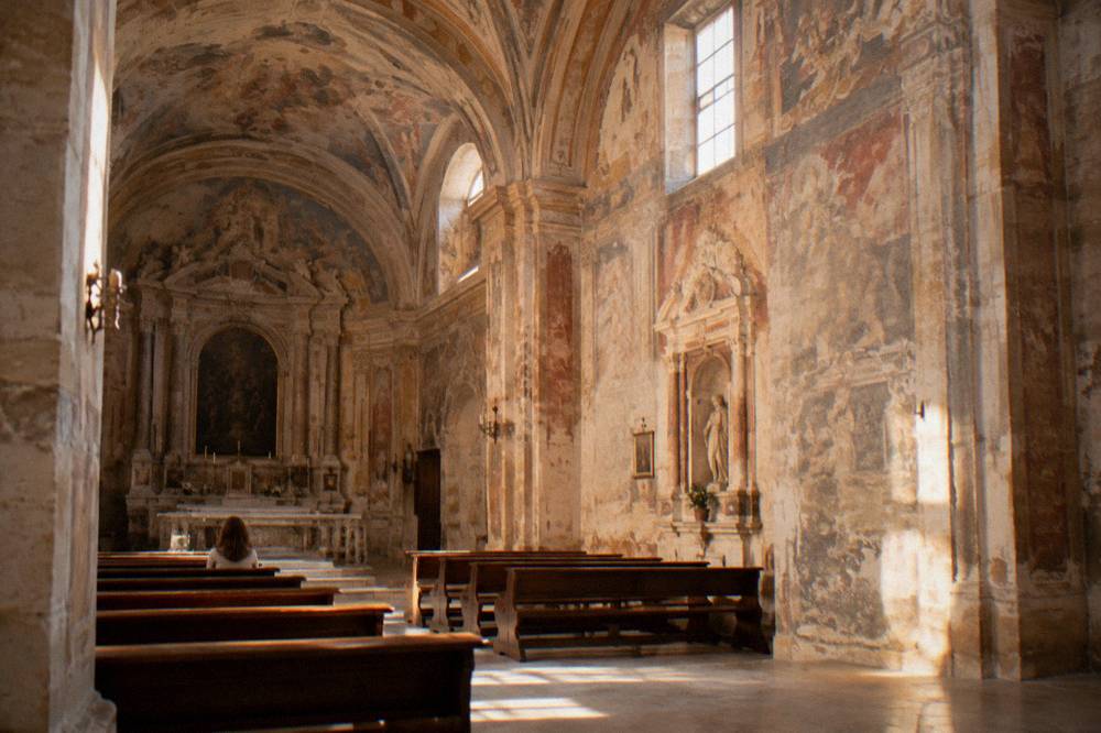 Interior of a church with painted frescoes covering the walls and vaulted ceiling