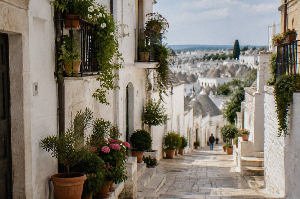 Narrow white lane in Locorotondo old town with plants on balconies