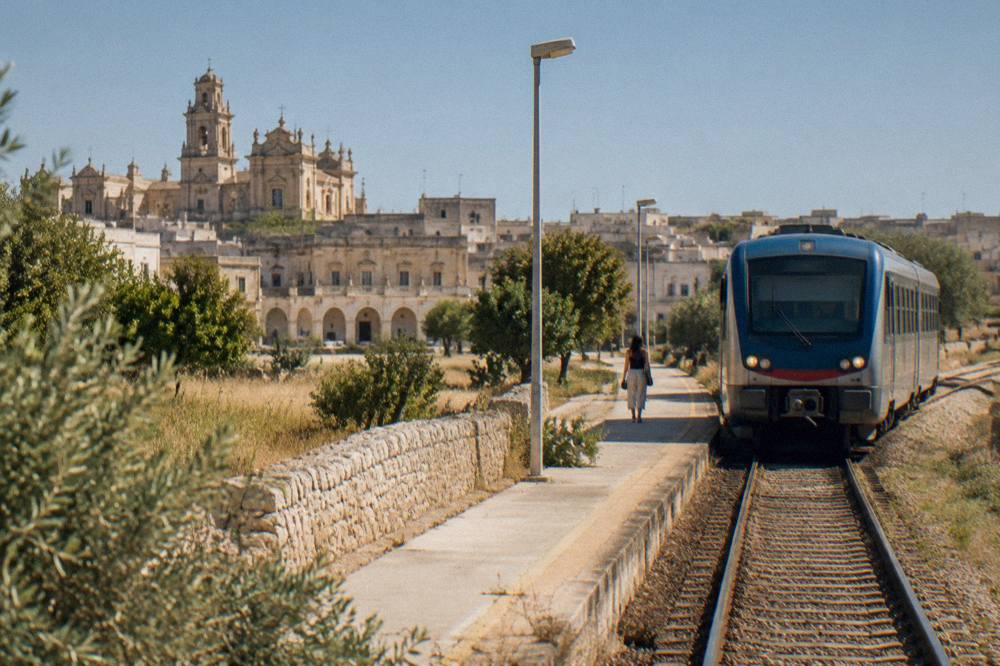 A regional train at a small station in the Salento countryside