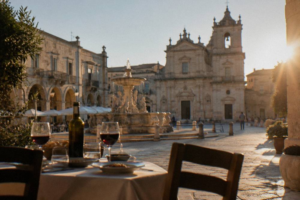 A table set for lunch with local wine in a shaded square
