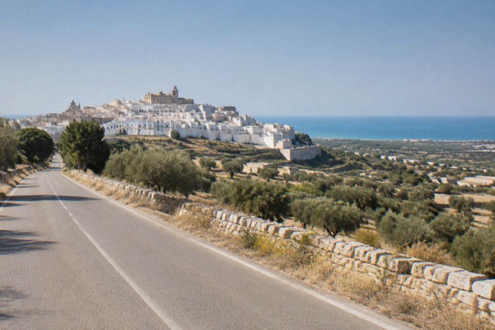 Empty two-lane road running through dry countryside in Puglia