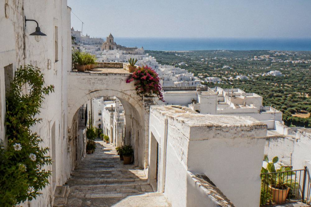 Narrow whitewashed lane with an arched passage in Ostuni's old centre
