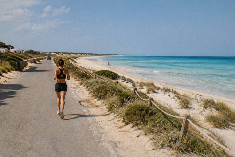 Coast road along the Ionian shore with sand dunes and sea beyond at Pescoluse
