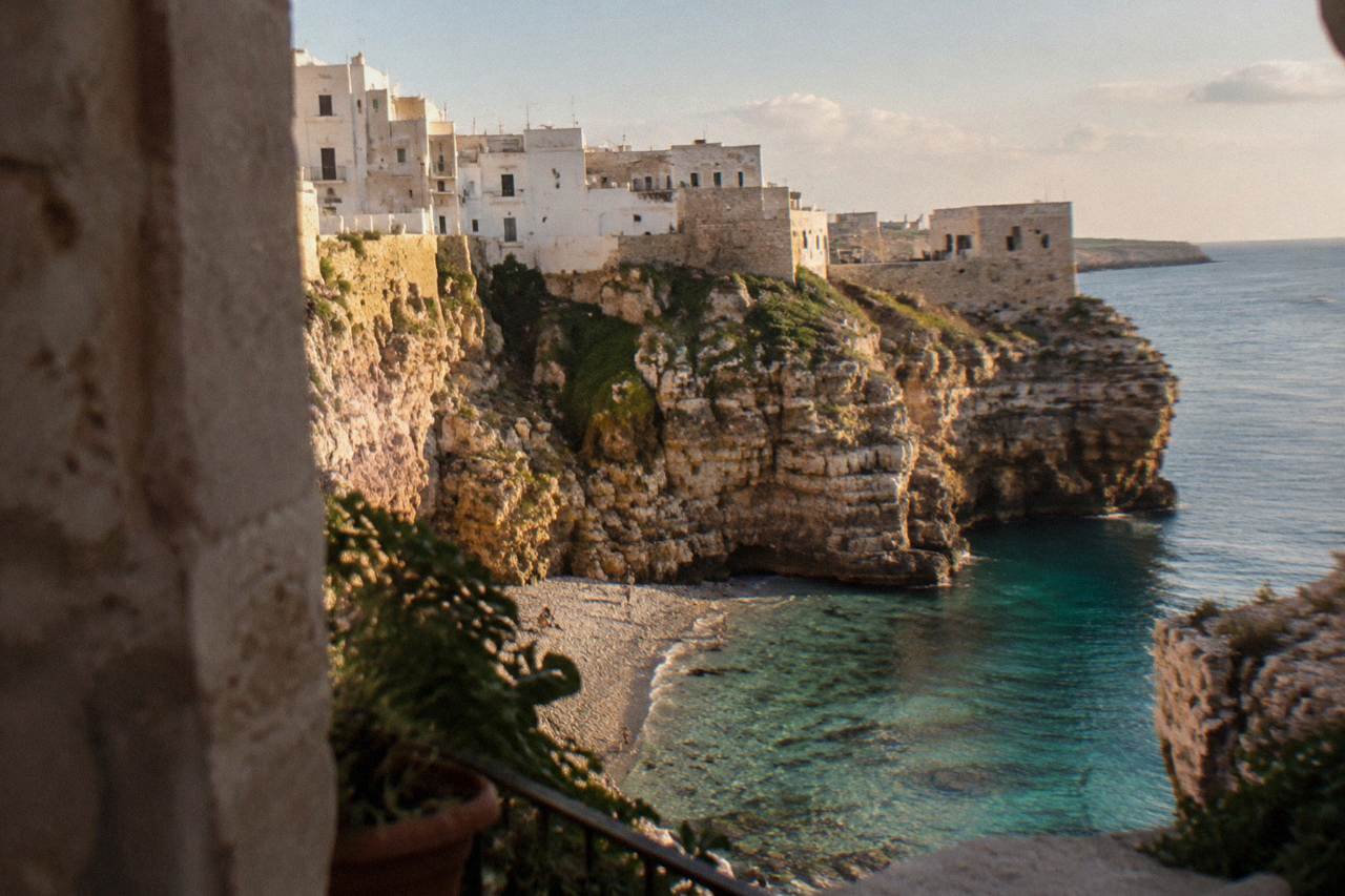 A clifftop town above the Adriatic Sea with pale stone buildings and calm blue water below