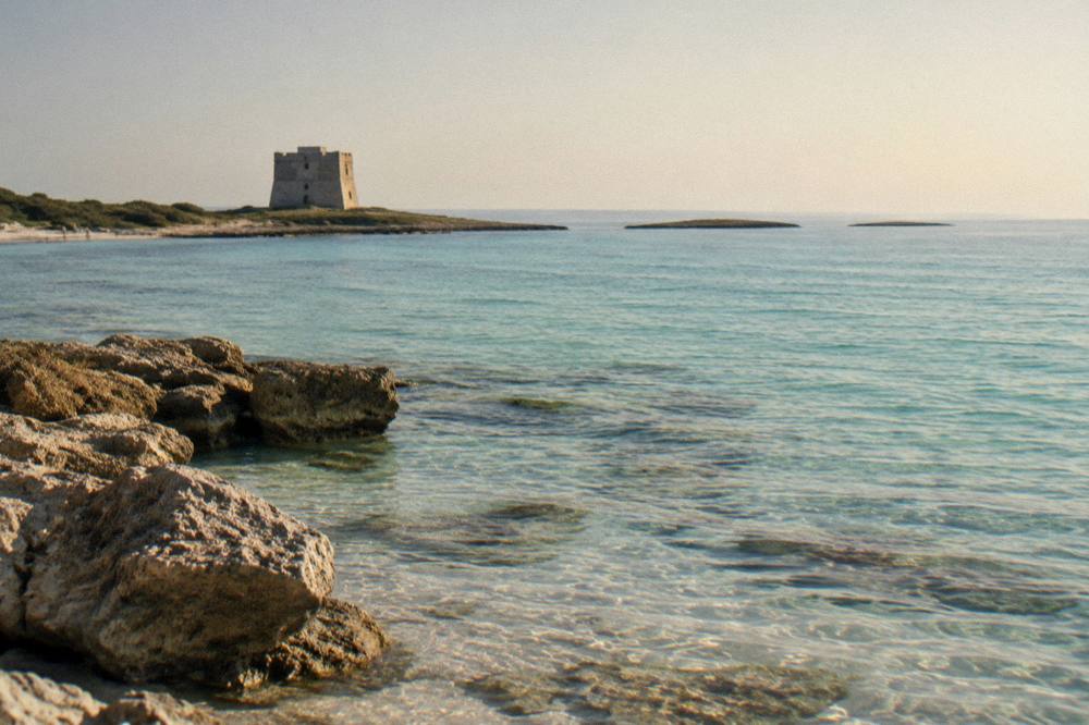 Evening light over calm Ionian water with the silhouette of a coastal tower