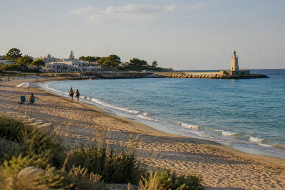 A quiet sandy beach at late afternoon with long shadows and calm sea