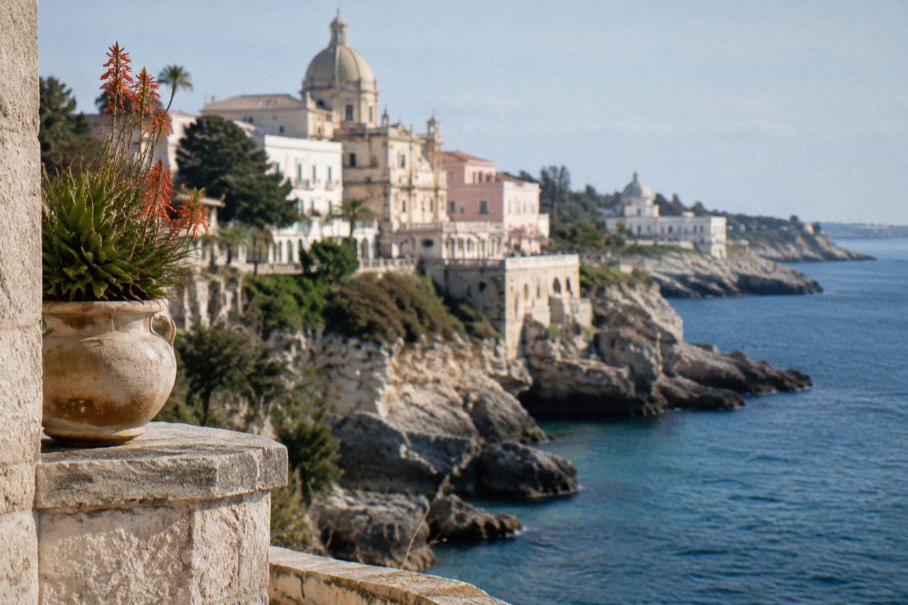 Pastel cliffside buildings above a rocky Adriatic coastline in southern Puglia