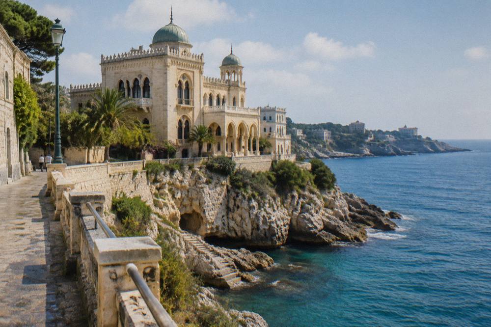 An ornate Moorish-style villa with domes and arched windows above a seaside promenade
