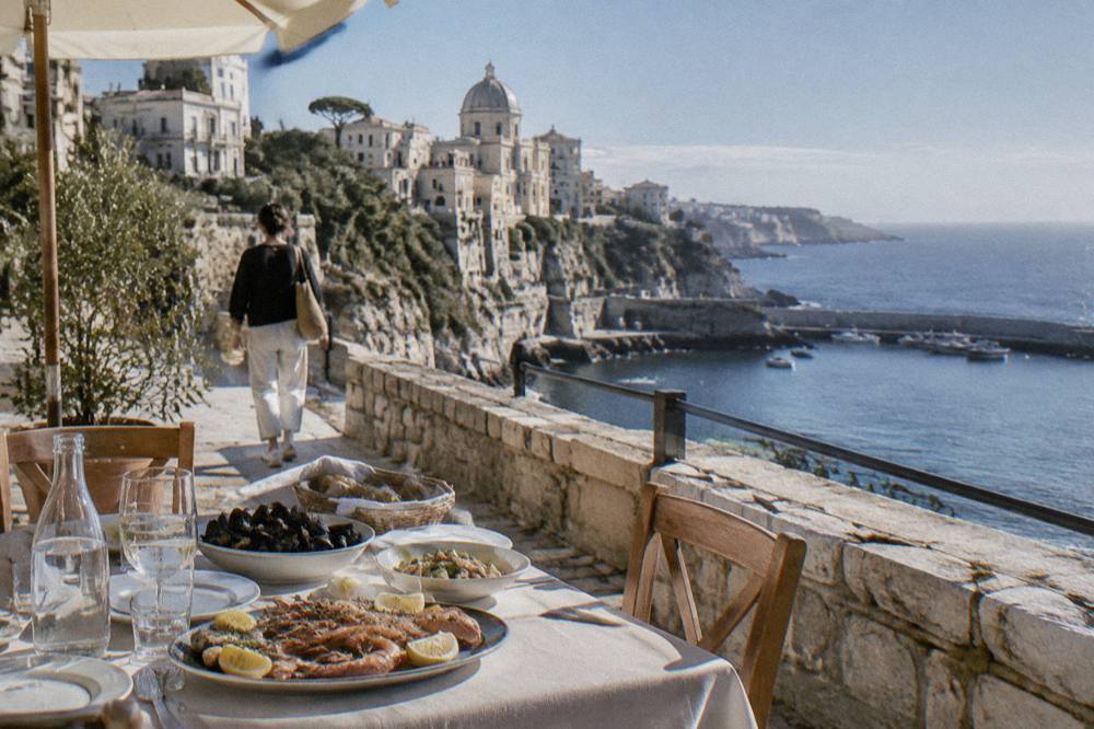 A seafood lunch table set on a terrace overlooking a harbour