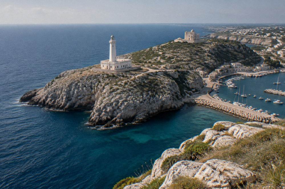 Lighthouse on a rocky headland above a deep blue sea