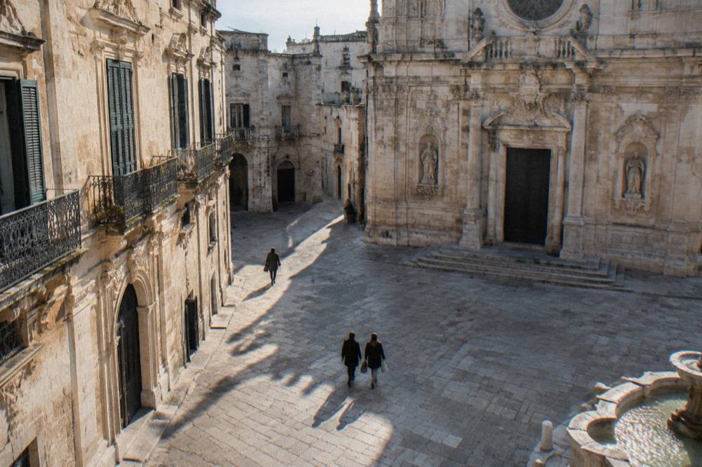 An ornate baroque church facade carved from pale limestone in a city piazza