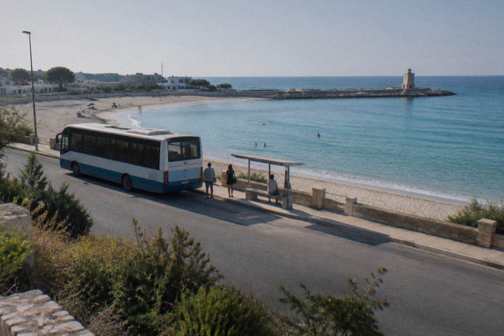 A regional bus parked at a seaside stop on a summer afternoon in Salento