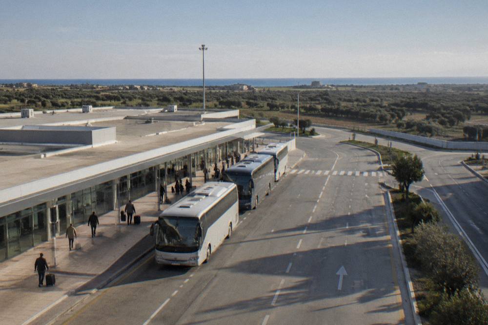 A signposted road leaving an airport with flat countryside beyond