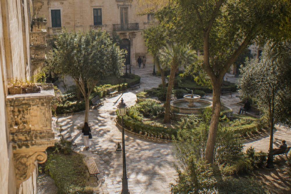 Shaded paths and benches in an ornamental public garden in Lecce