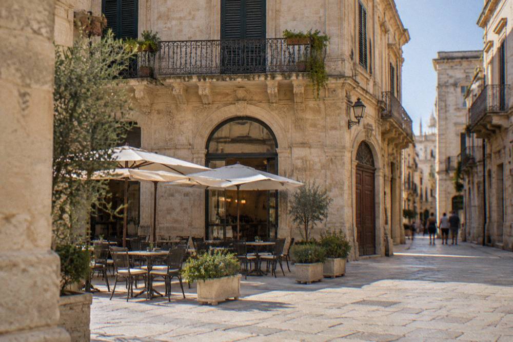 The facade of a historic cafe on a sunlit square in Lecce