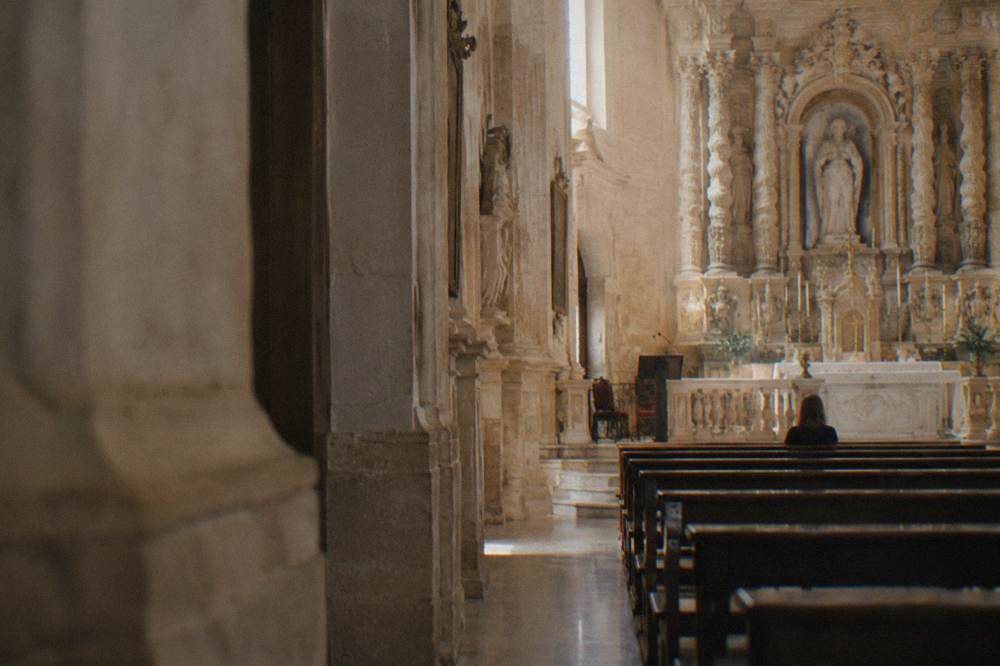 A quiet baroque church interior in Lecce with ornate stone altar and soft daylight