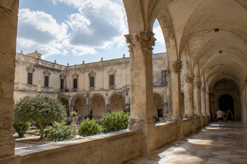A cloister walkway with stone arches at the Antico Seminario in Lecce