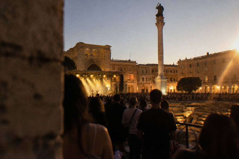 A crowded piazza in a small southern Italian town at night during an outdoor concert