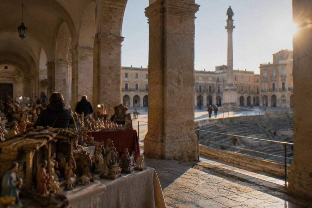 Craft stalls selling handmade nativity figures inside an Italian cloister at Christmas