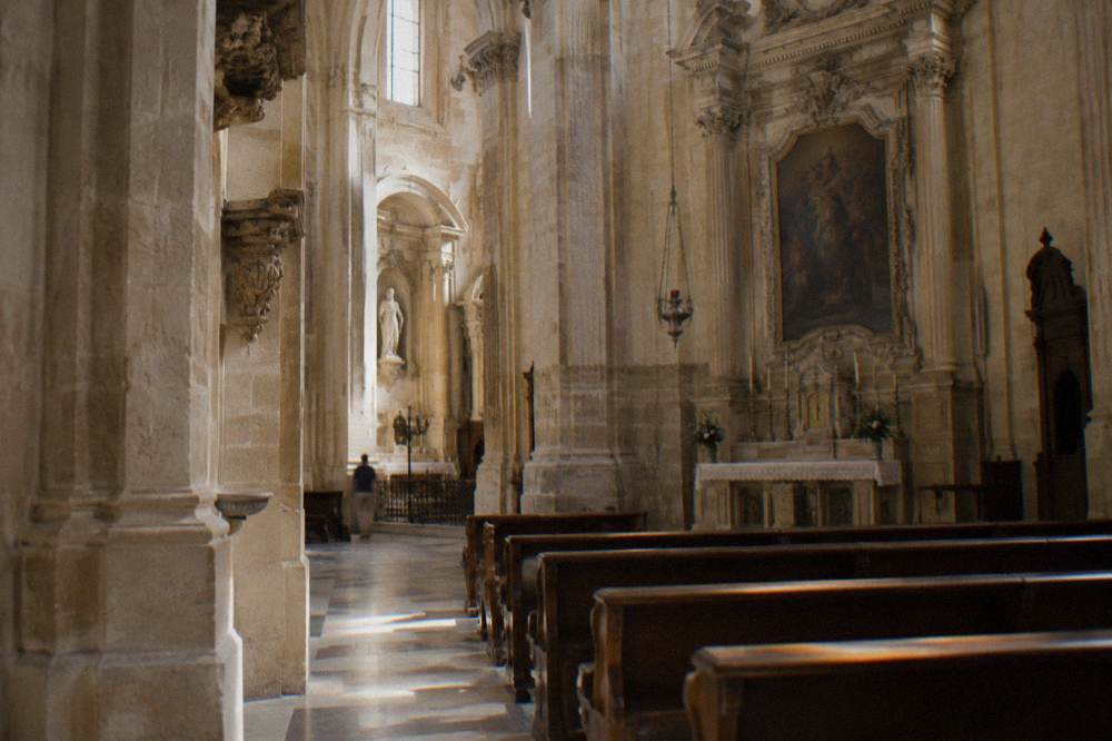Interior of a cool stone church in Lecce lit by soft afternoon light