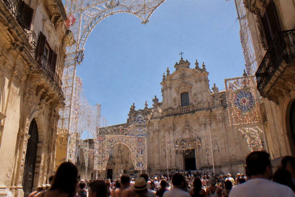 Festive illuminations over a crowded square in Lecce during the August patronal feast