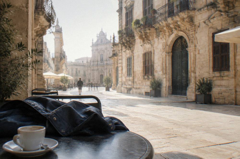 Rain jacket on a cafe table beside a cup of coffee in Lecce