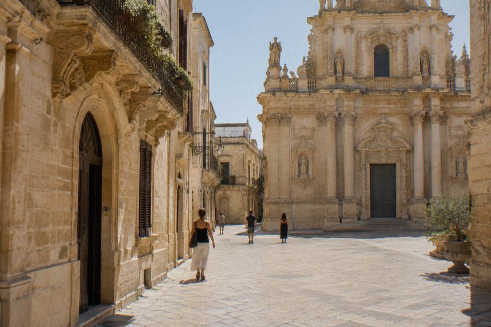 Elaborately carved baroque church facade in golden limestone with columns and statues